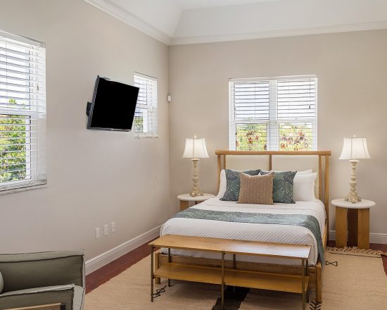 Blue Island Villa bedroom with seating area and wall-mounted TV