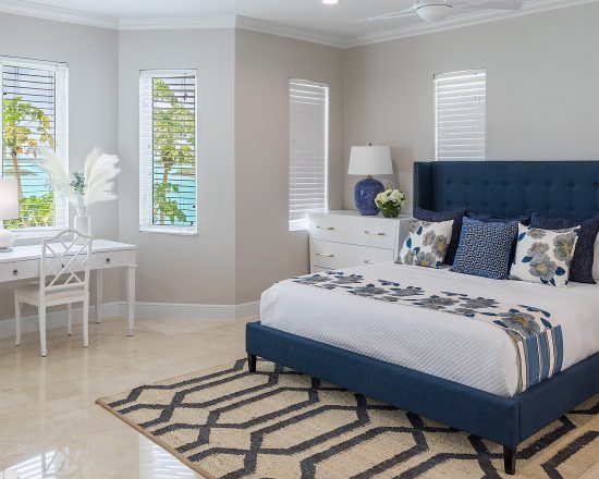 Blue Island Villa bedroom with desk and upholstered blue velvet headboard