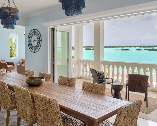 Blue Island Villa dining table with woven chairs and amazing water view