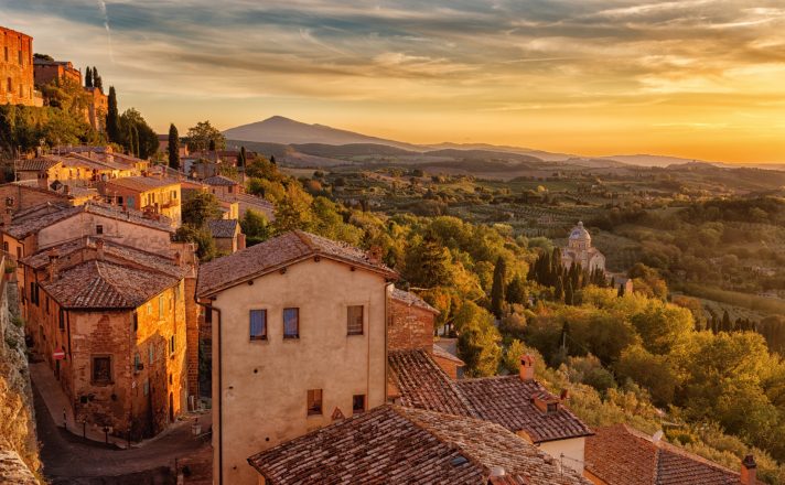 Aerial view of Cortona with golden sunlight bathing the hillside