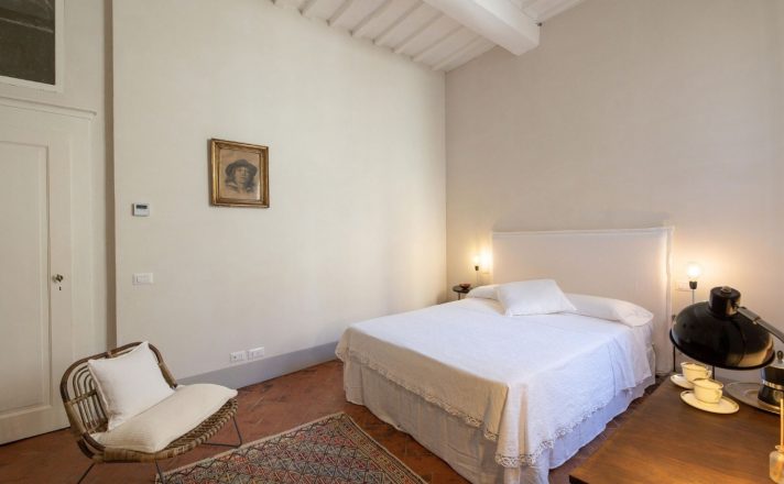 One of the bedrooms in Bella Aura with white walls, high ceilings, and a European king sized bed.