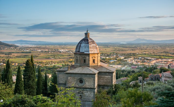 View from Cortona over the stone church and steeple into the surrounding flat valley