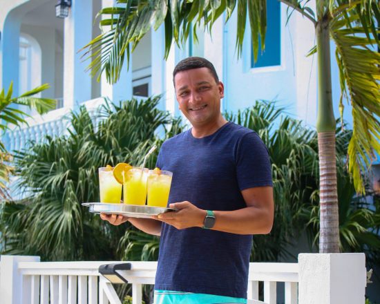 Friendly Blue Island Villa staff delivering drinks poolside