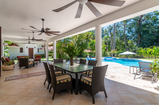 Covered outdoor dining area at Cabarete Dreams, featuring a table for 6, ceiling fans, a view of the pool