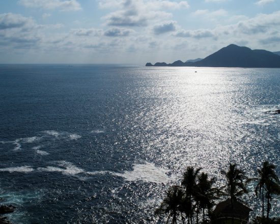Casa de Sofia water view, with mountain shadows in the background and palm tree silhouettes