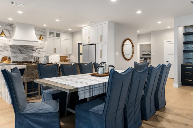 View of the dining room, which seats at least 8 and features blue slipcovered chairs.
