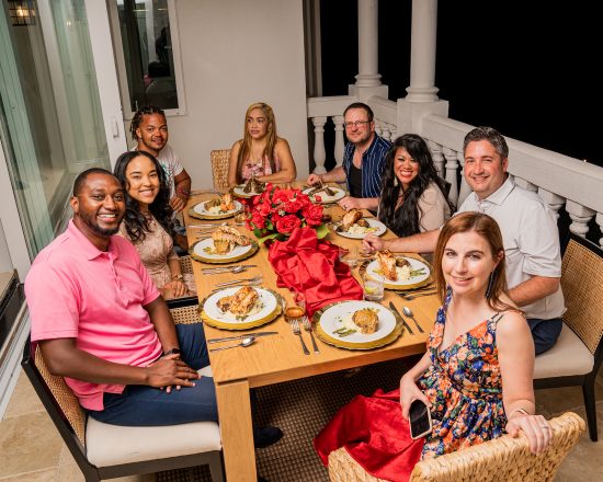 Blue Island Villa guests enjoying an outdoor meal at night on the patio balcony