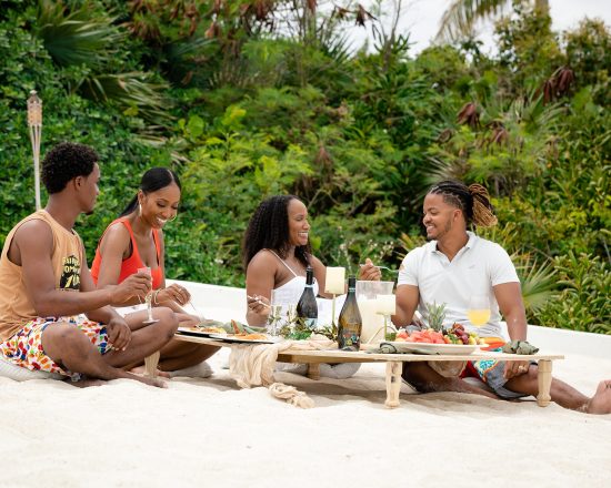 Blue Island Villa guests enjoying lunch with fresh fruit and wine on the beach