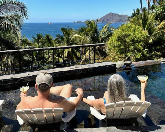 Casa de Sofia guests enjoying the view with their chairs in the shallow end of the infinity pool