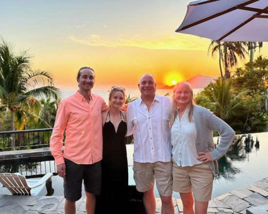 Casa de Sofia guests posing in front of the pool at sunset