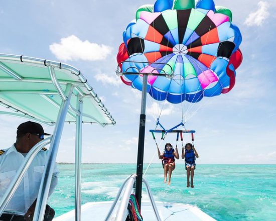 Blue Island Villa guests parasailing with a colorful chute